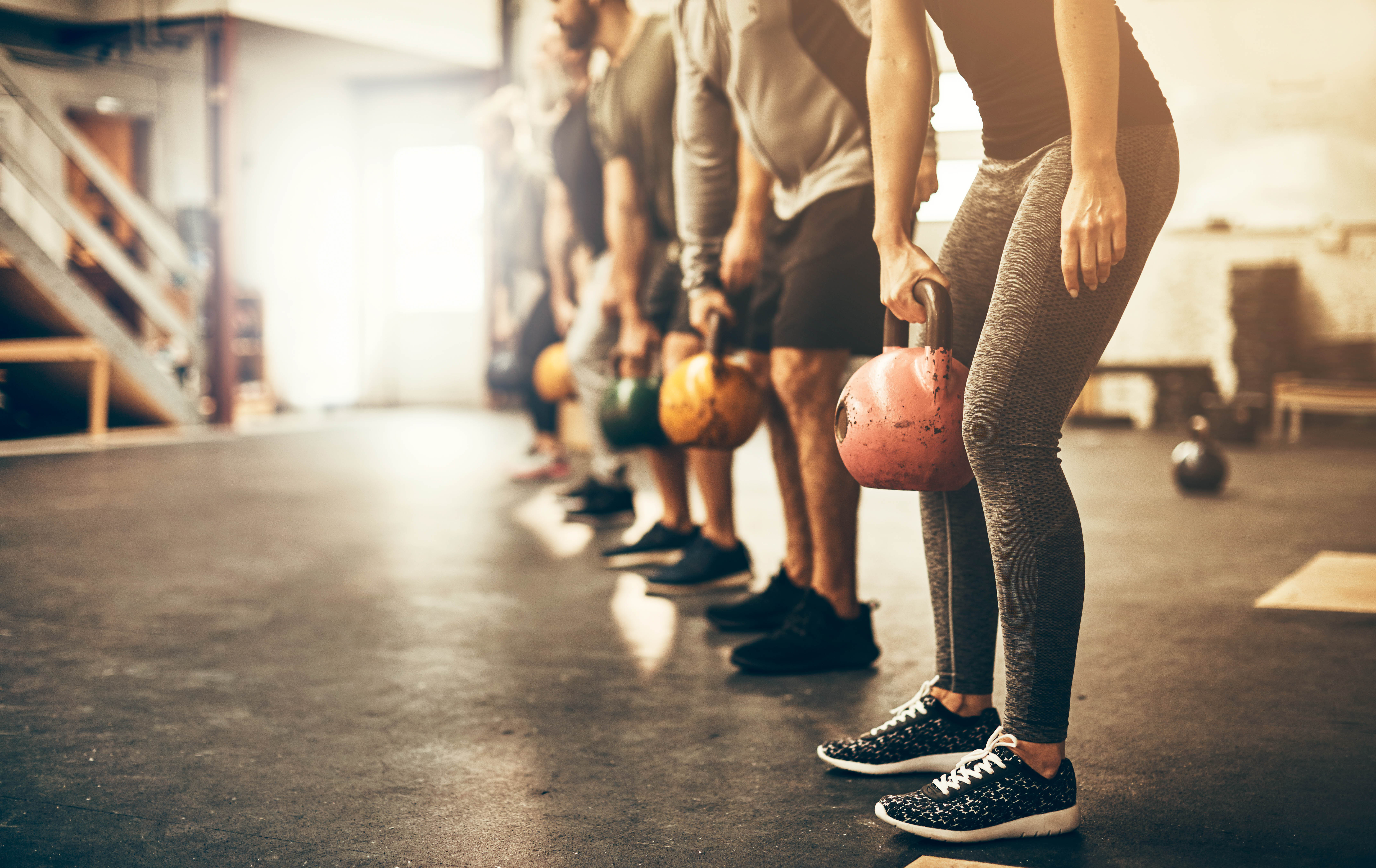 Close-up of torsos for a group fitness class, holding kettlebells